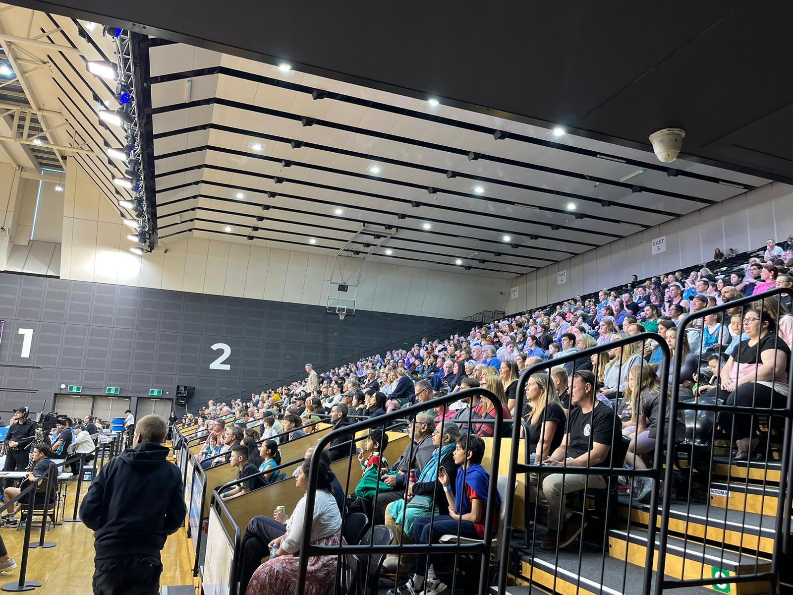 Fans filling the seating at an indoor basketball arena