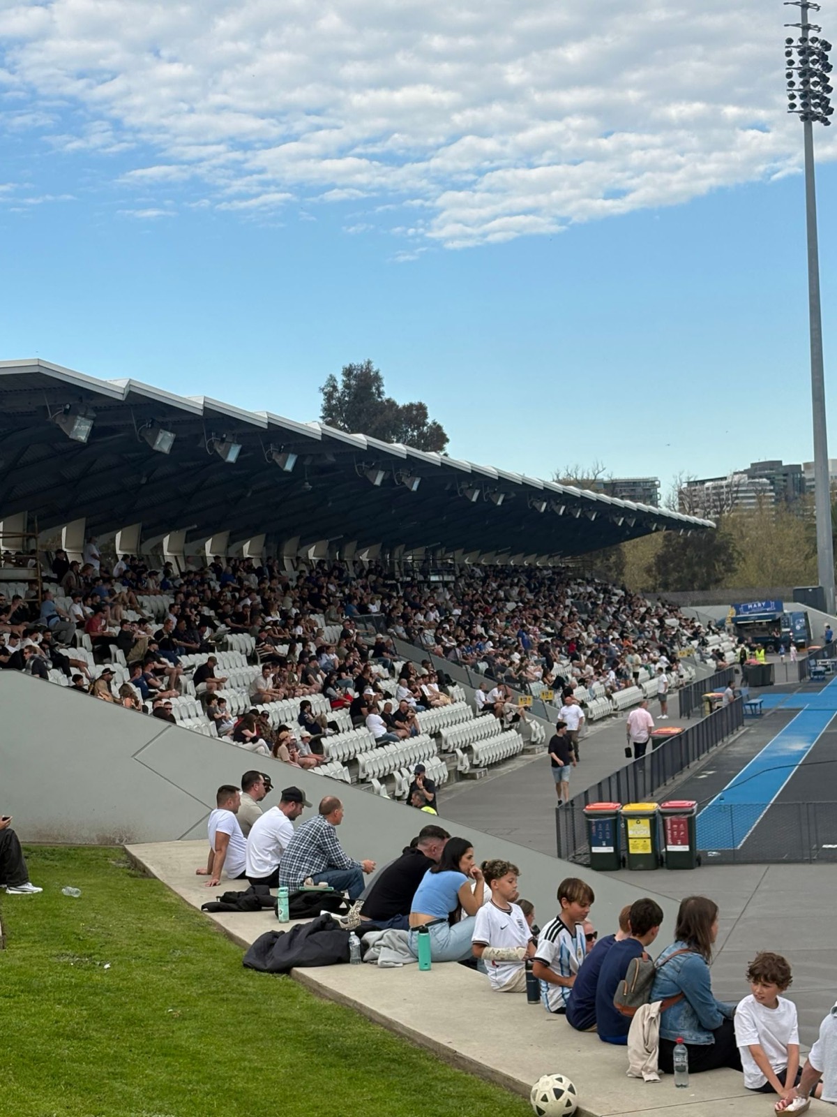 Families and fans in the grandstand on a sunny matchday